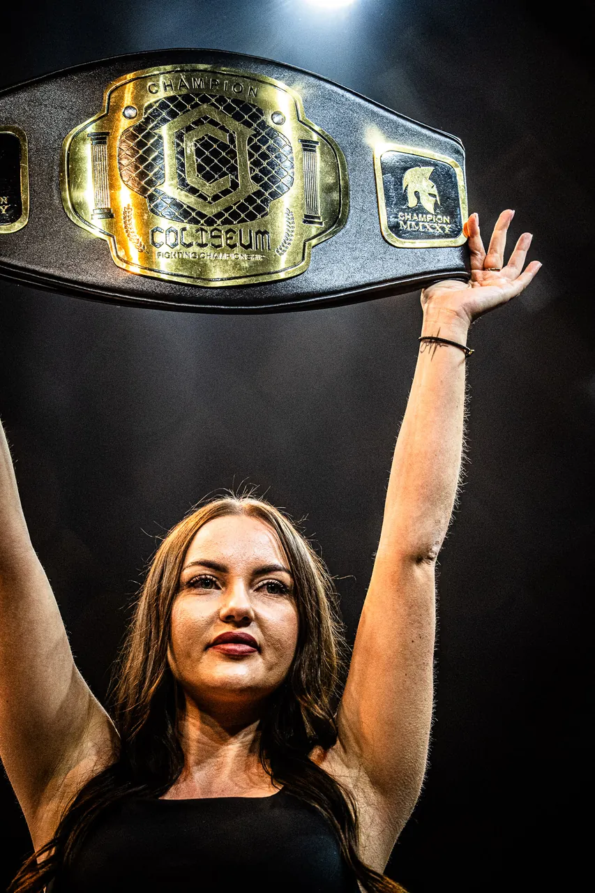 La ceinture de champion Coliseum brandie au centre de la cage